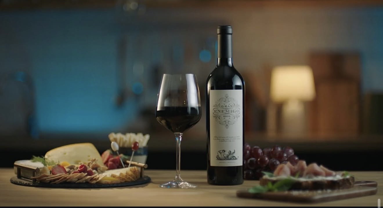 Bodegón de vino, copa, quesos y alimentos sobre una mesa