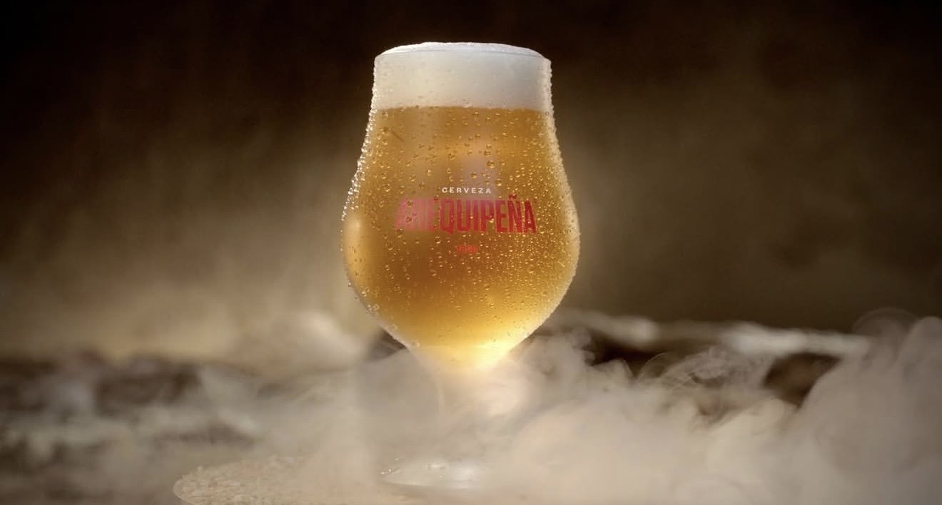 Copa de cerveza Arequipeña iluminada entre vapor