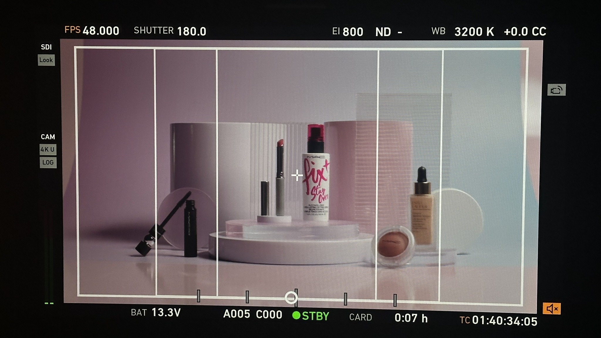 Monitor de cámara mostrando un bodegón de maquillaje compuesto con fondos y plataformas rosados